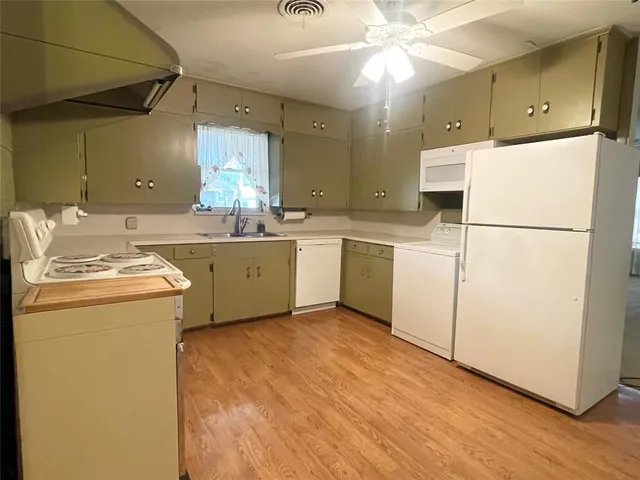 a kitchen with a sink a stove a refrigerator and cabinets