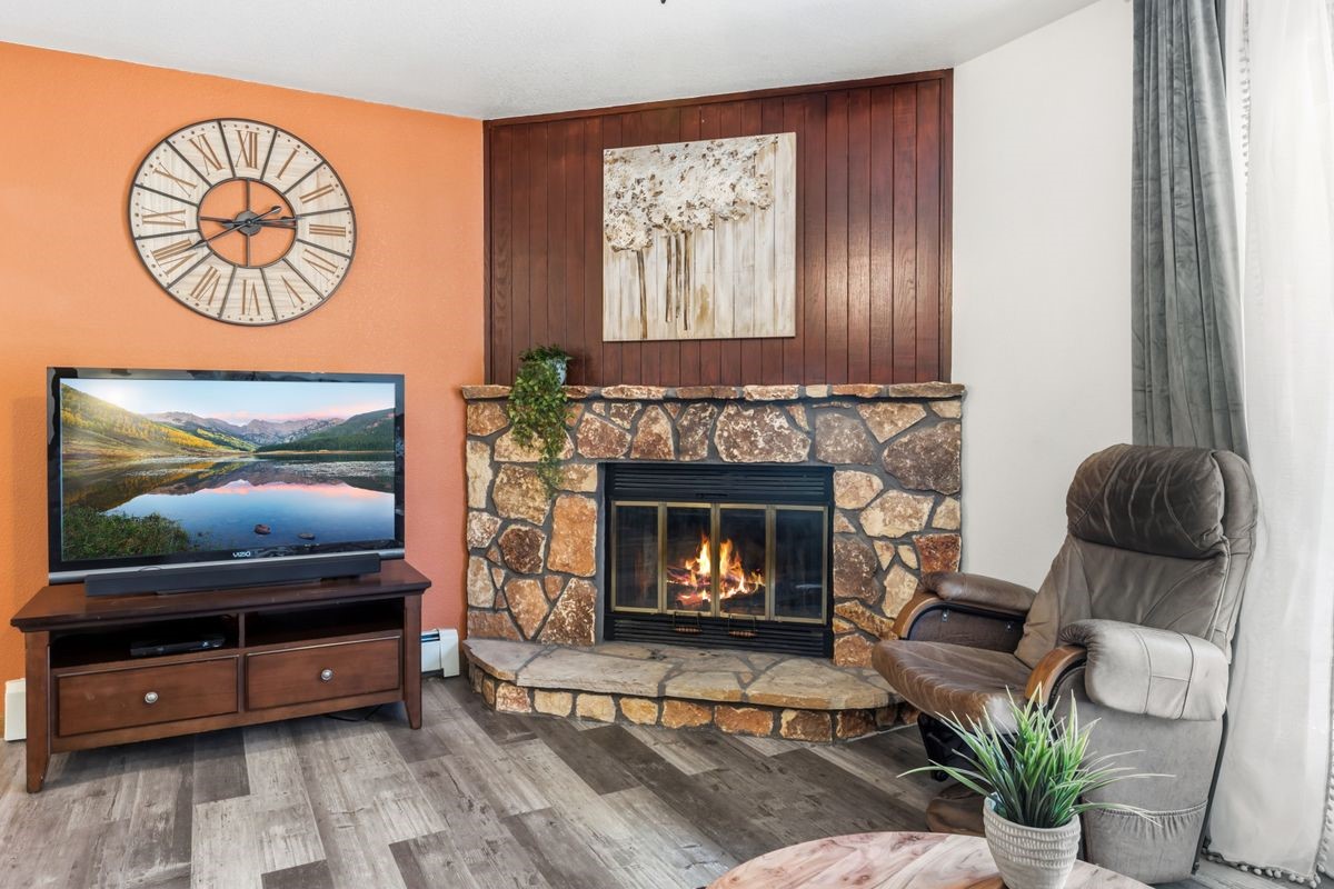 89410 Ryan Gulch Road, Unit 208 Silverthorne, CO 80498 - Photo 11 of 30 a living room with furniture and a fireplace