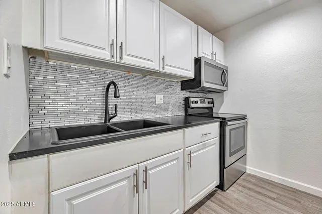 a kitchen with stainless steel appliances granite countertop a sink a stove and a granite counter tops