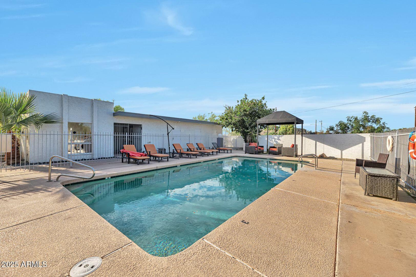 4231 North 13th Place, Unit 110 Phoenix, AZ 85014 - Photo 9 of 9 a view of a patio with a table and chairs under an umbrella
