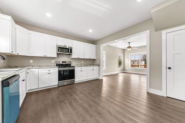 a kitchen with granite countertop white cabinets and white appliances