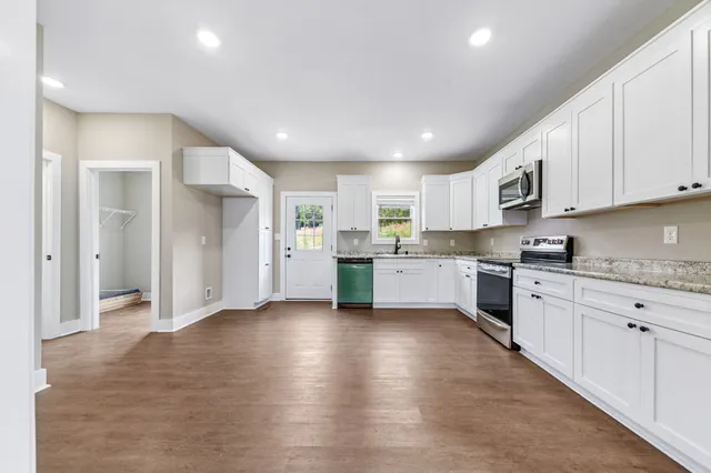 a view of empty room with windows and ceiling fan