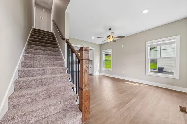 a view of a hallway with wooden floor and staircase