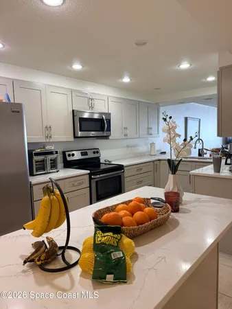 a kitchen with stainless steel appliances a stove a sink a microwave a refrigerator and cabinets