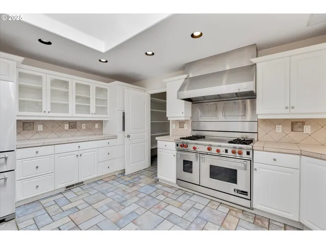 a kitchen with granite countertop white cabinets stainless steel appliances and sink