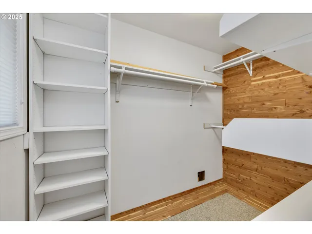a view of walk in closet with empty racks