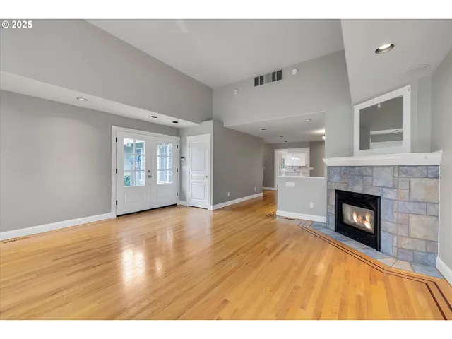 a view of empty room with wooden floor and fireplace