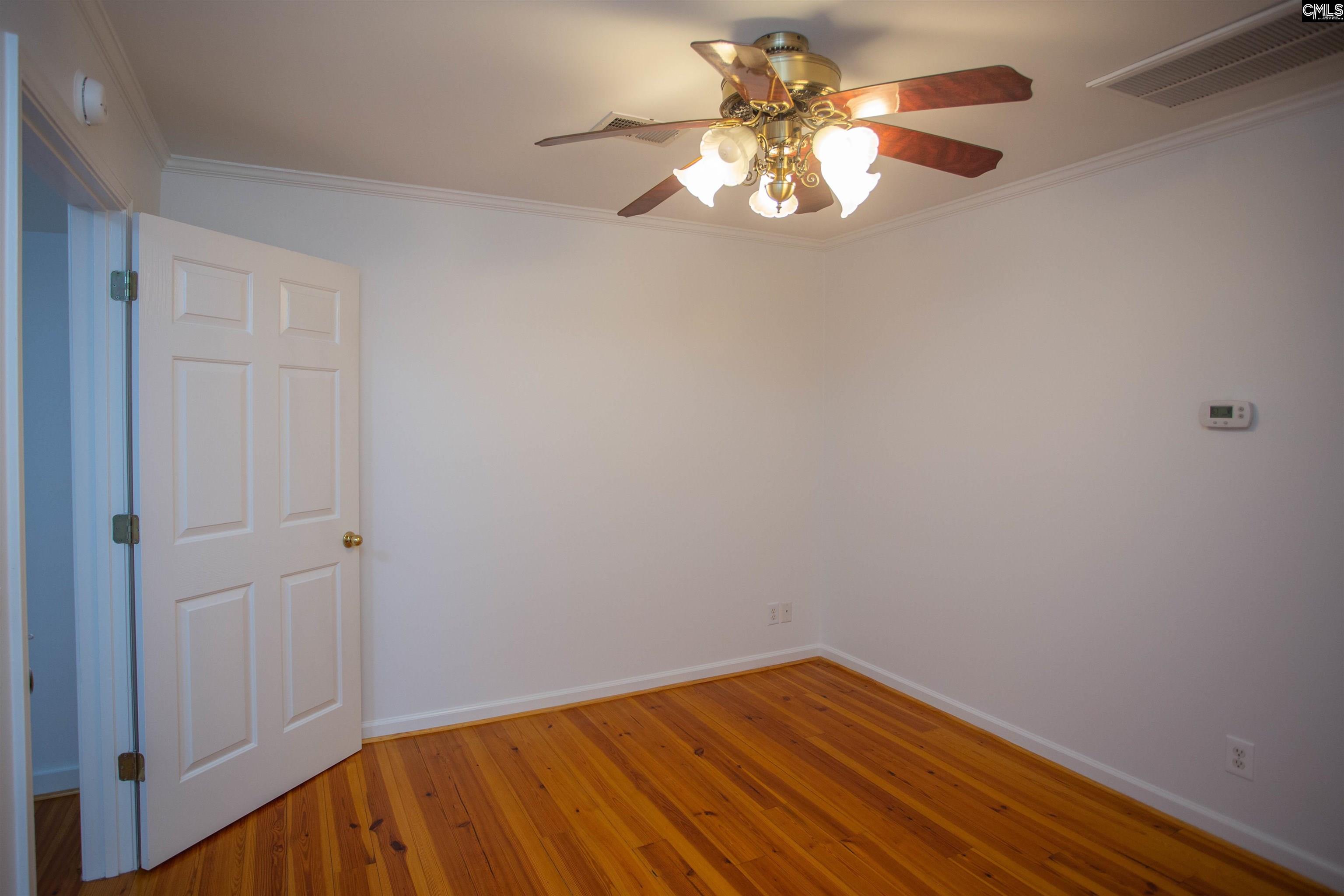 1700 Broad Street Camden, SC 29020 - Photo 30 of 41 an empty room with a chandelier fan and wooden floor
