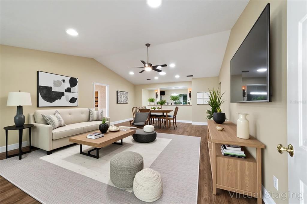 9068 Southwest 82nd Terrace, Unit A Ocala, FL 34481 - Photo 5 of 30 a living room with furniture and a chandelier