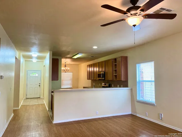 a view of a kitchen with a sink and wooden cabinet