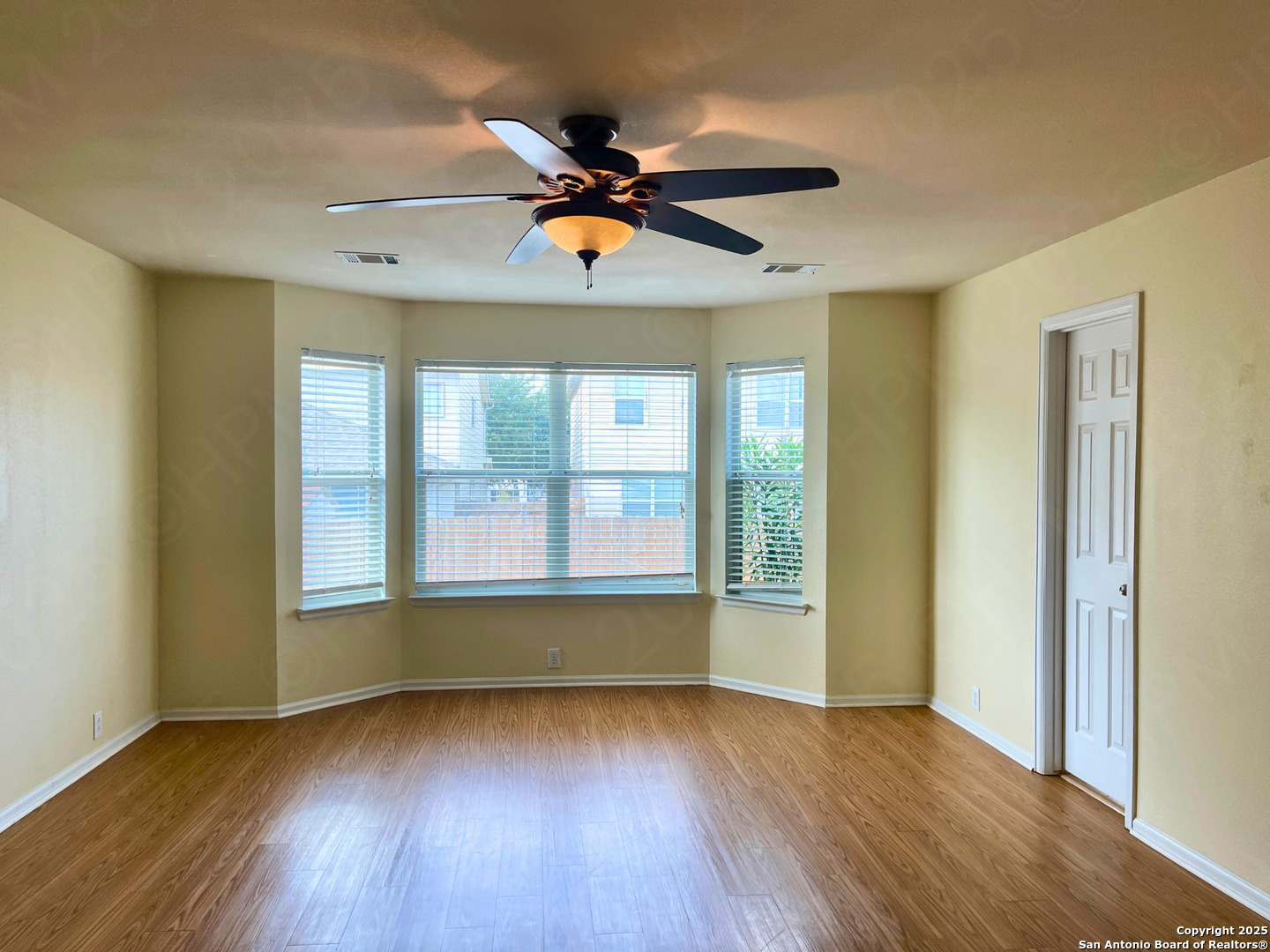 9523 Ascending Port Converse, TX 78109 - Photo 10 of 18 an empty room with wooden floor fan and windows