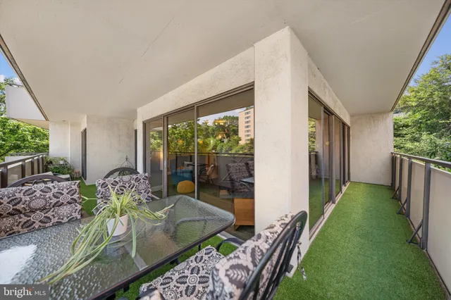 a living room with furniture floor to ceiling window and wooden floor