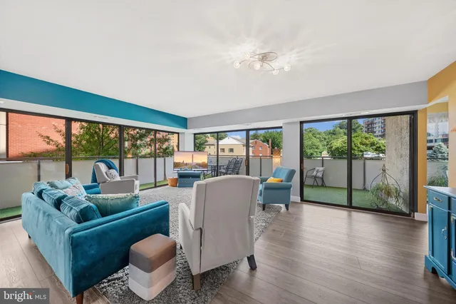 a living room with furniture and a large window with wooden floor