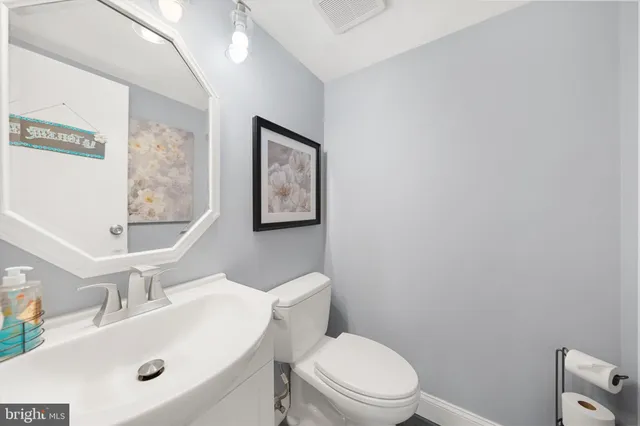 a bathroom with a sink mirror vanity and toilet