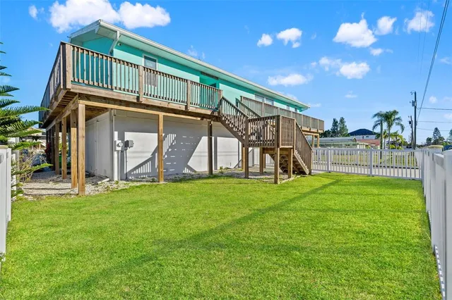 an aerial view of ocean and residential houses with outdoor space