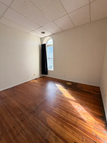a view of empty room with wooden floor