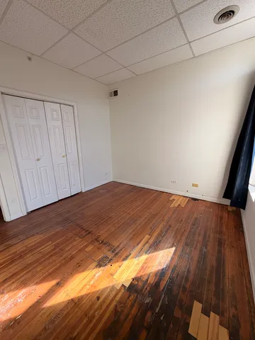 a view of empty room with wooden floor