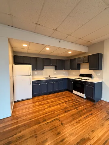 a large kitchen with kitchen island granite countertop wooden cabinets and a sink