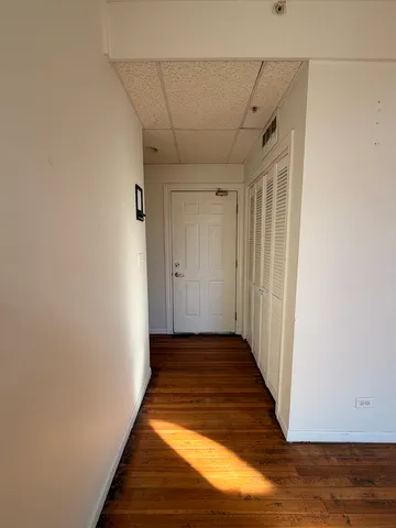 a view of a kitchen with wooden floor and cabinets