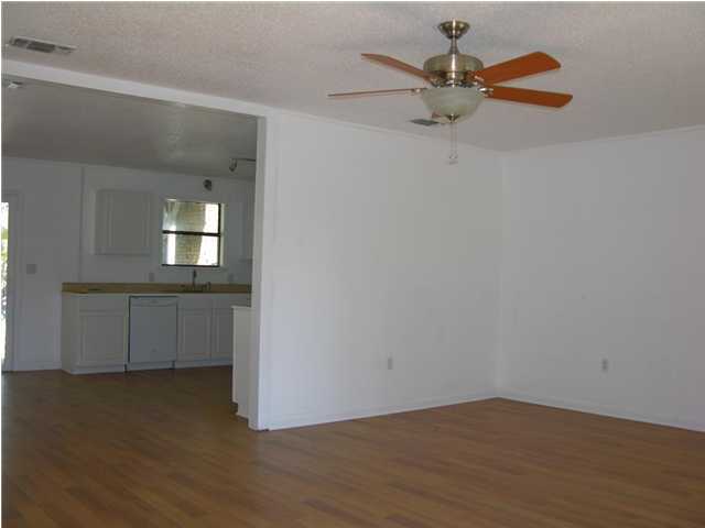 4555 Rainbird Rise Road Crestview, FL 32539 - Photo 4 of 32 wooden floor in an empty room with a window