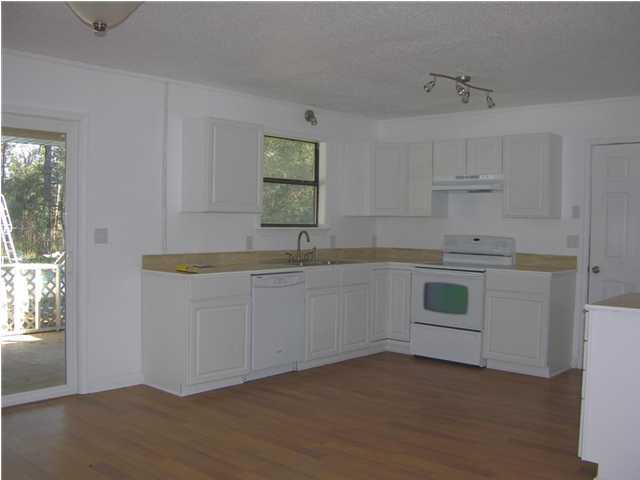 4555 Rainbird Rise Road Crestview, FL 32539 - Photo 7 of 32 a kitchen with granite countertop white cabinets and white appliances