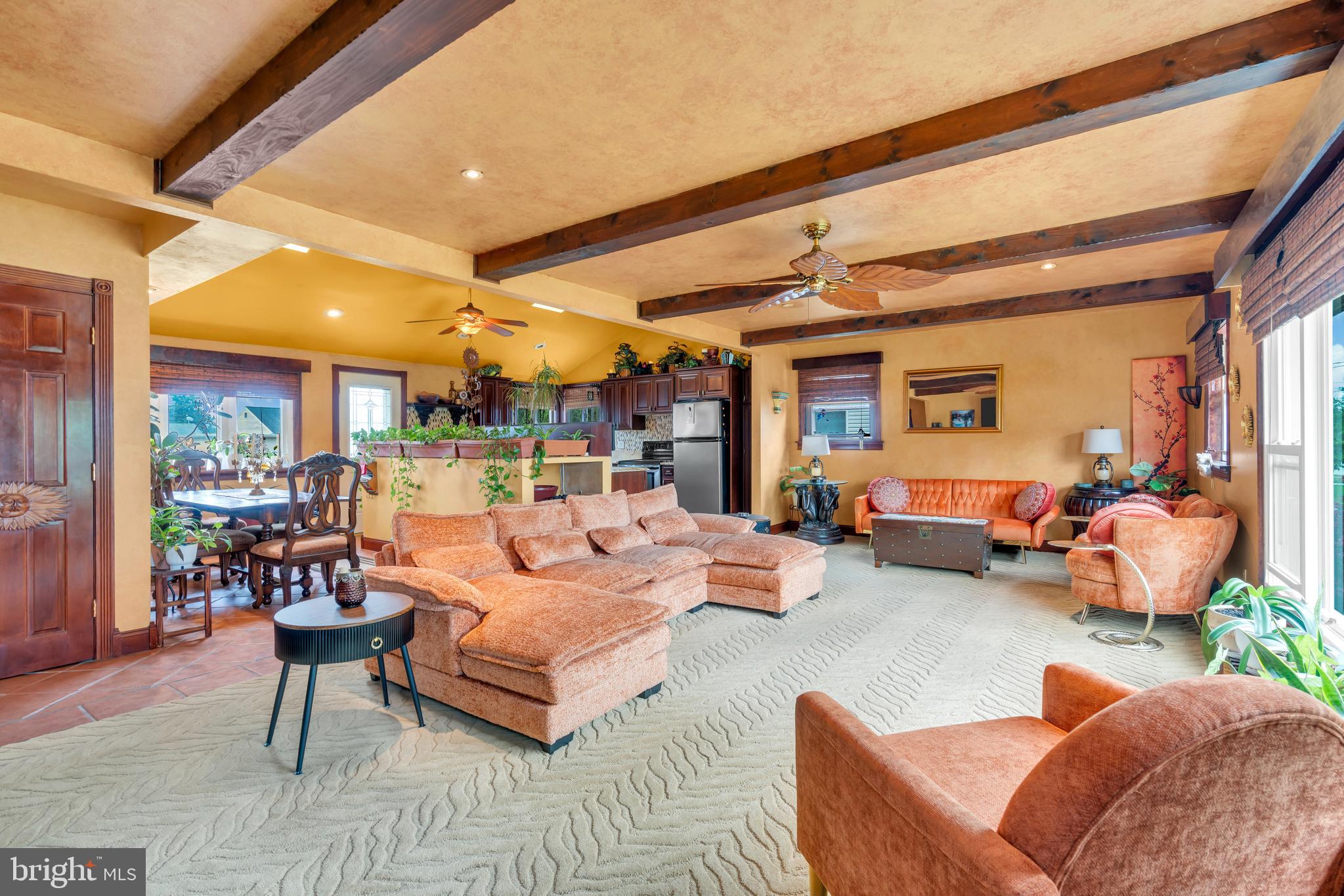 a living room with furniture kitchen view and a large window