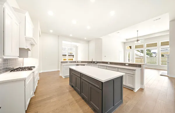 an empty room with wooden floor fireplace and windows