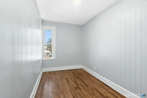 a view of a room with wooden floor and window