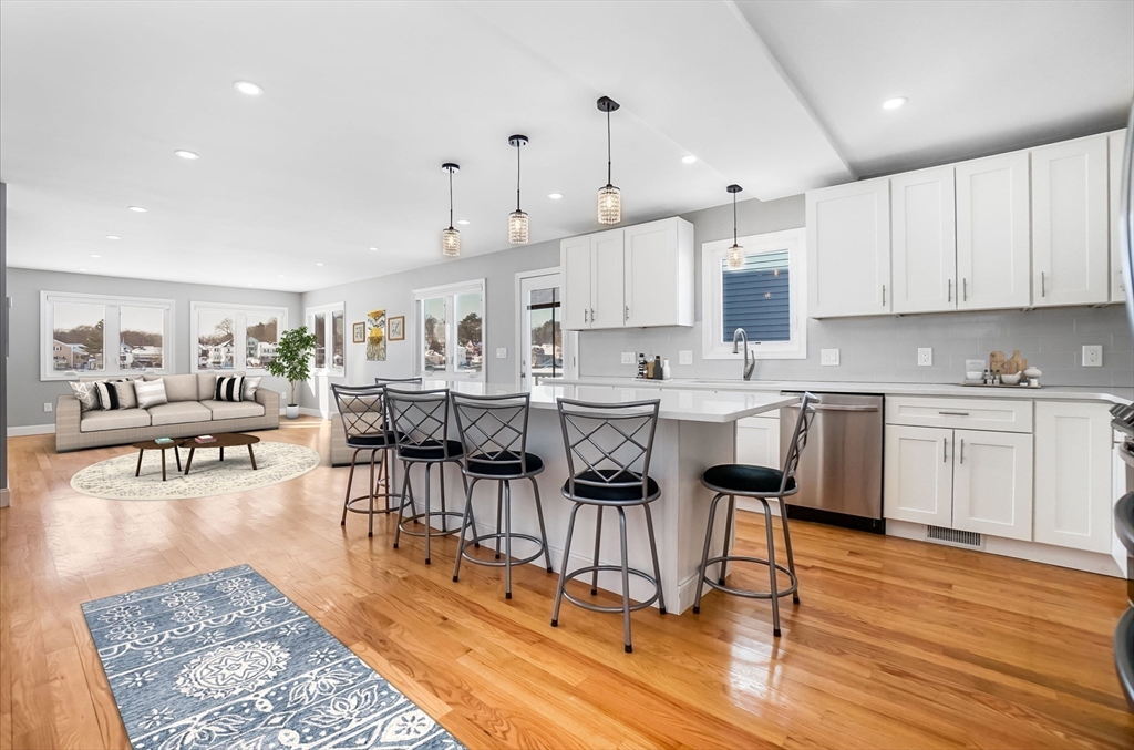 52 Savory Street, Unit 52 Lynn, MA 01904 - Photo 1 of 29 a open kitchen with stainless steel appliances granite countertop a stove top oven a refrigerator a sink and white cabinets with wooden floor
