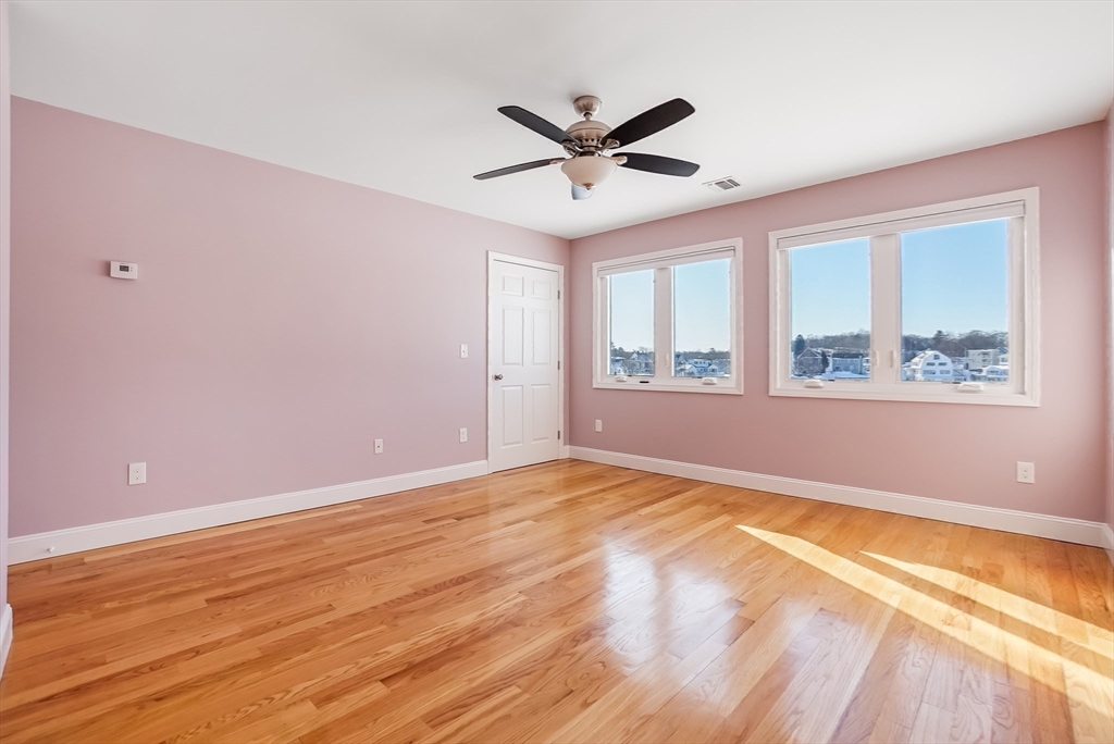 52 Savory Street, Unit 52 Lynn, MA 01904 - Photo 8 of 29 a view of an empty room with a window and wooden floor