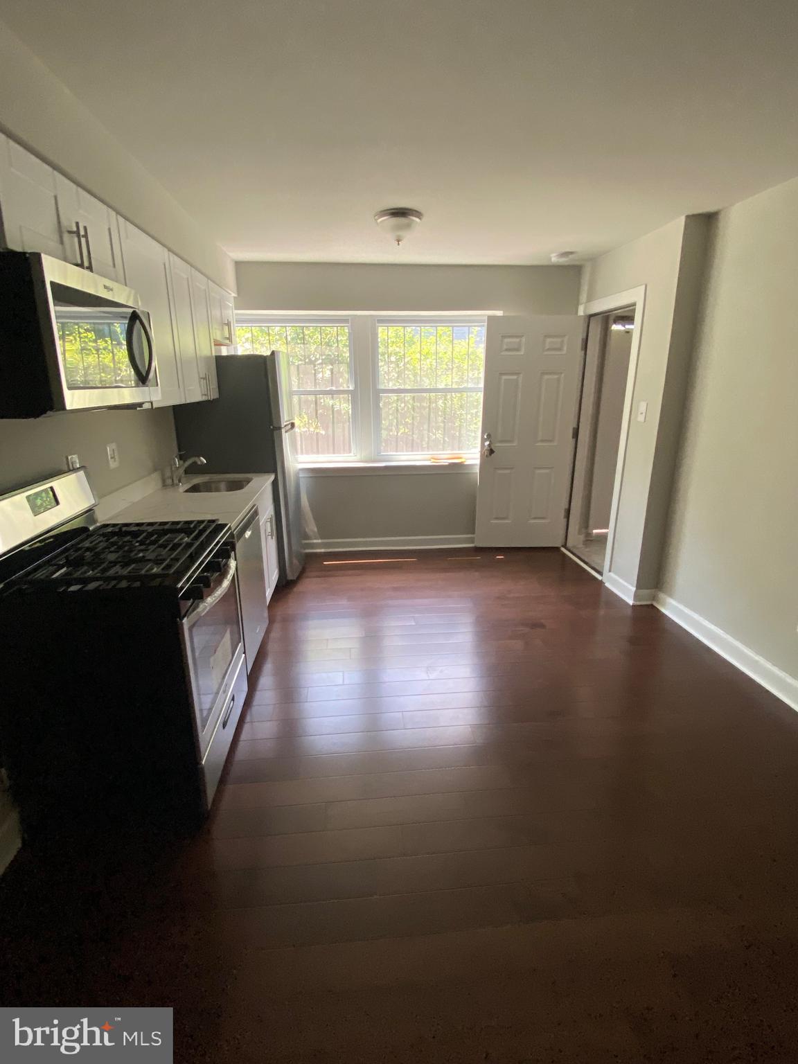 52 Forrester Street Southwest Washington, DC 20032 - Photo 16 of 18 a kitchen that has a sink wooden floor and a window