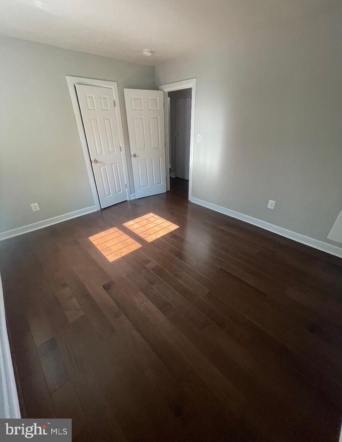 52 Forrester Street Southwest Washington, DC 20032 - Photo 4 of 18 an empty room with wooden floor and windows