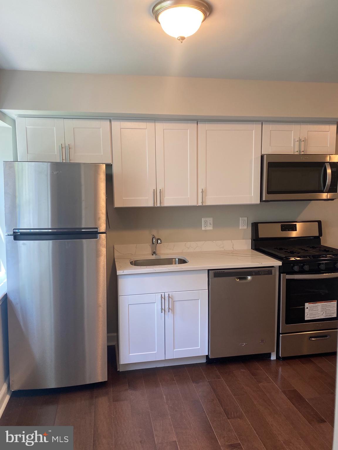 52 Forrester Street Southwest Washington, DC 20032 - Photo 6 of 18 a kitchen with stainless steel appliances granite countertop a refrigerator a stove a sink and a microwave