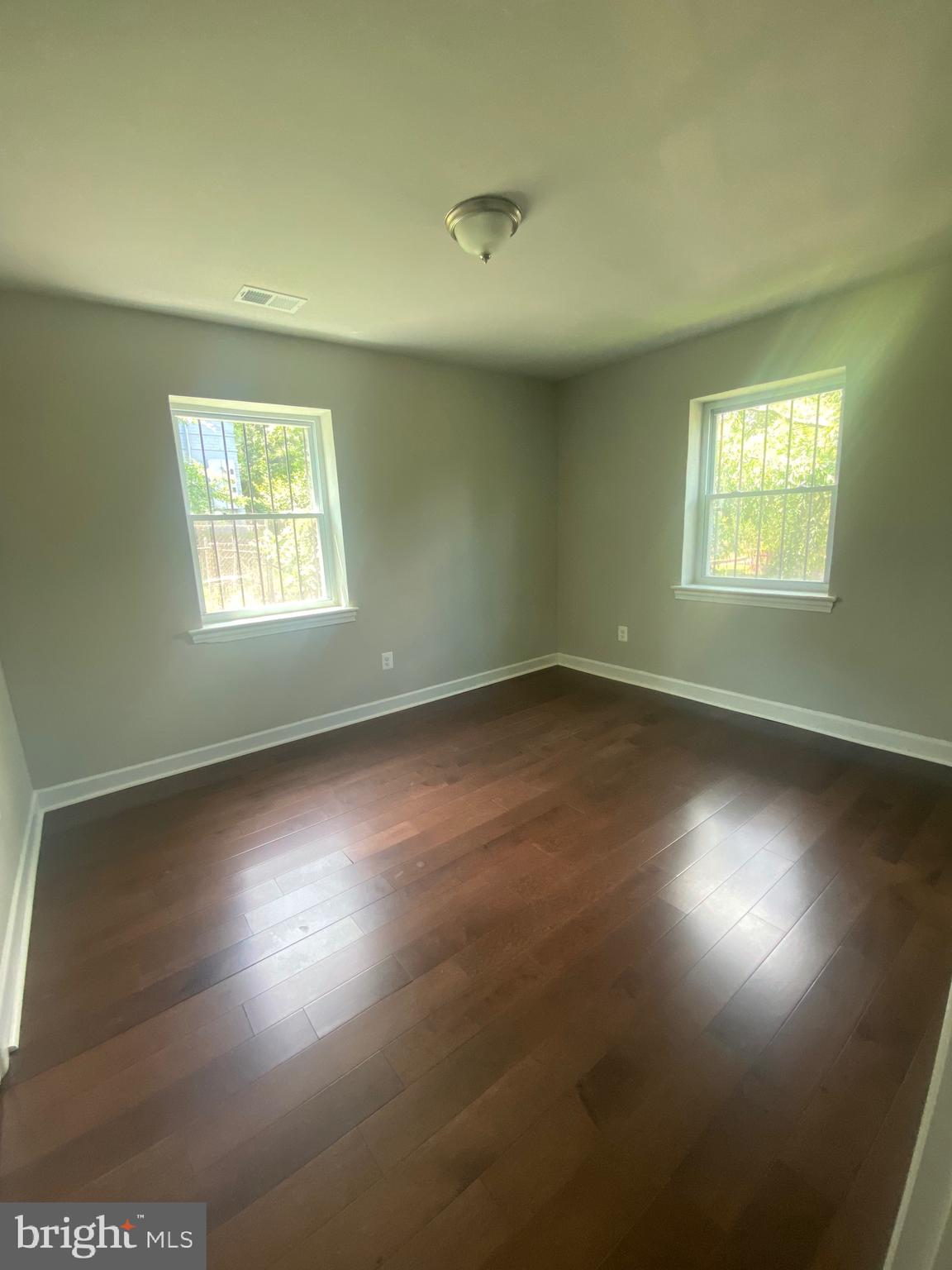 52 Forrester Street Southwest Washington, DC 20032 - Photo 7 of 18 an empty room with wooden floor and windows