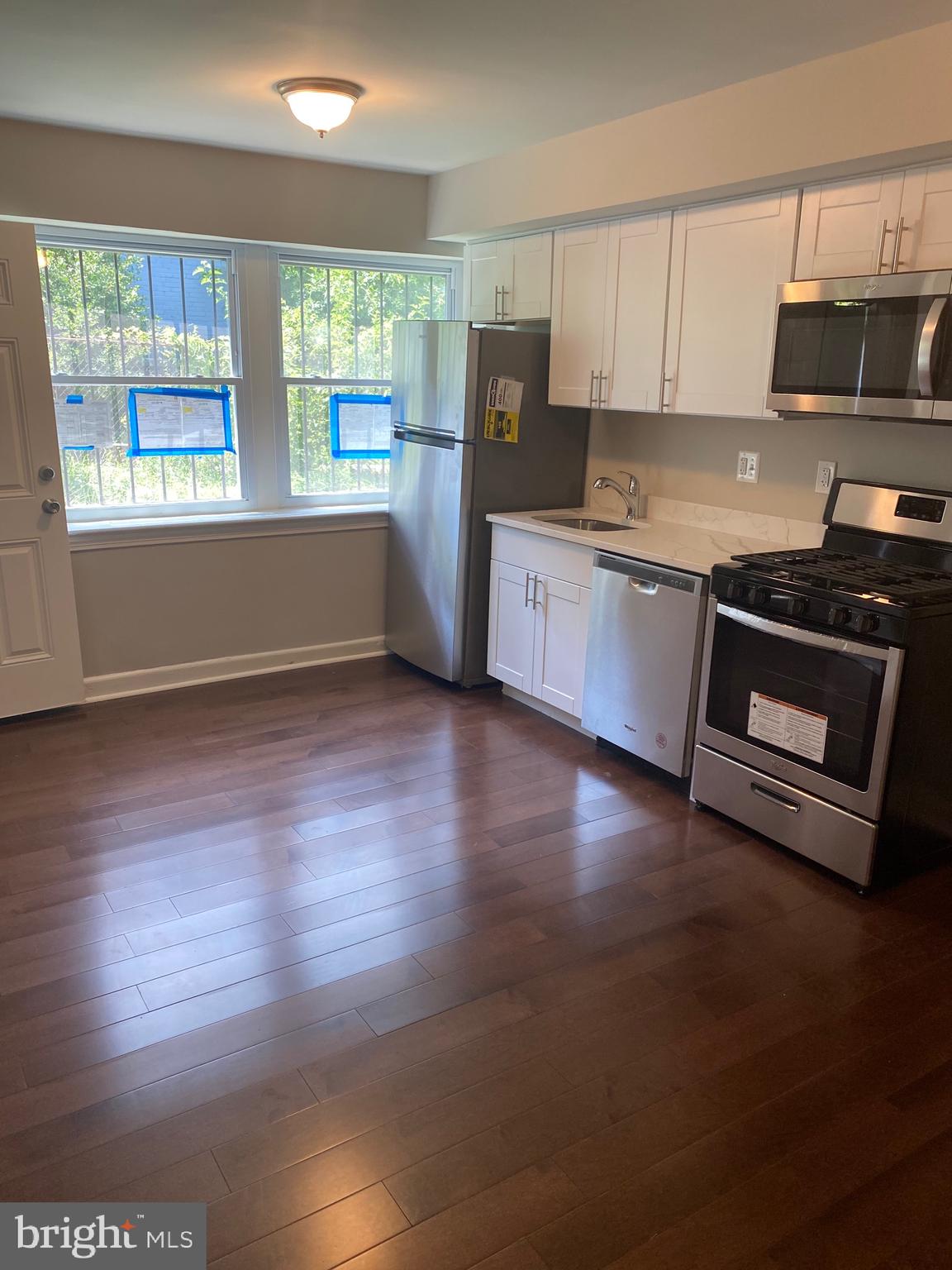 52 Forrester Street Southwest Washington, DC 20032 - Photo 8 of 18 a kitchen with granite countertop wooden floors and stainless steel appliances