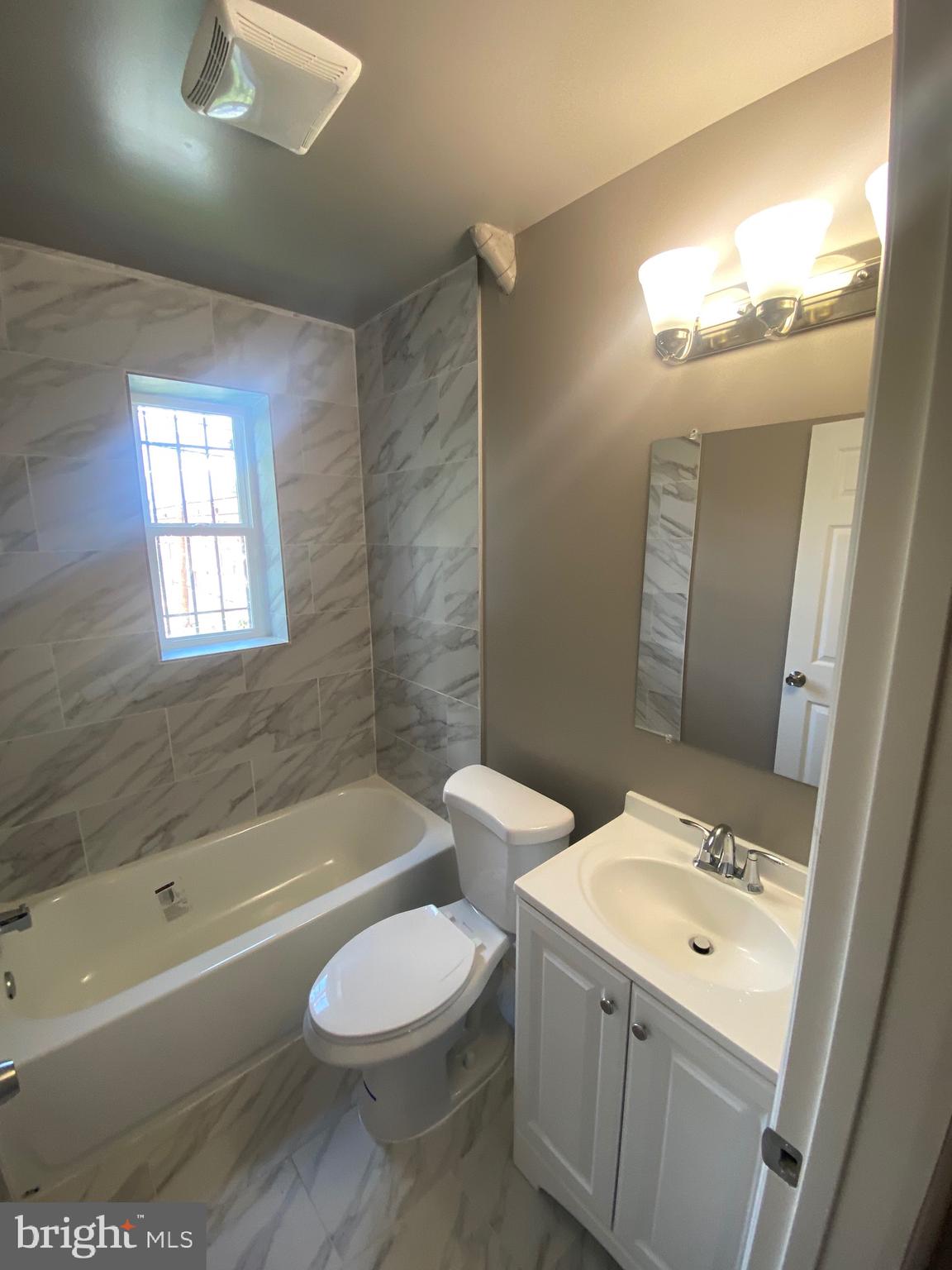 52 Forrester Street Southwest Washington, DC 20032 - Photo 10 of 18 a bathroom with a bathtub shower sink vanity mirror and toilet