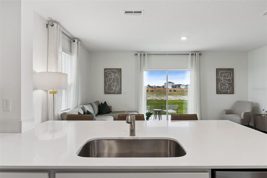 4356 Butterscotch Circle Lakeland, FL 33811 - Photo 10 of 30 a kitchen with kitchen island a sink and a refrigerator