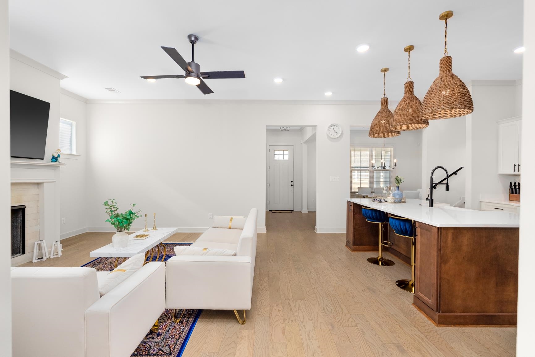 Living room with light wood-style flooring, a fireplace, ornamental molding, ceiling fan, and recessed lighting