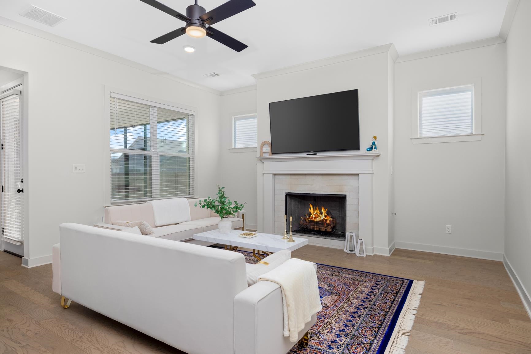 5628 Gerber Road Arlington, TN 38002 - Photo 11 of 40 Living area featuring crown molding, wood finished floors, a warm lit fireplace, a ceiling fan, and recessed lighting