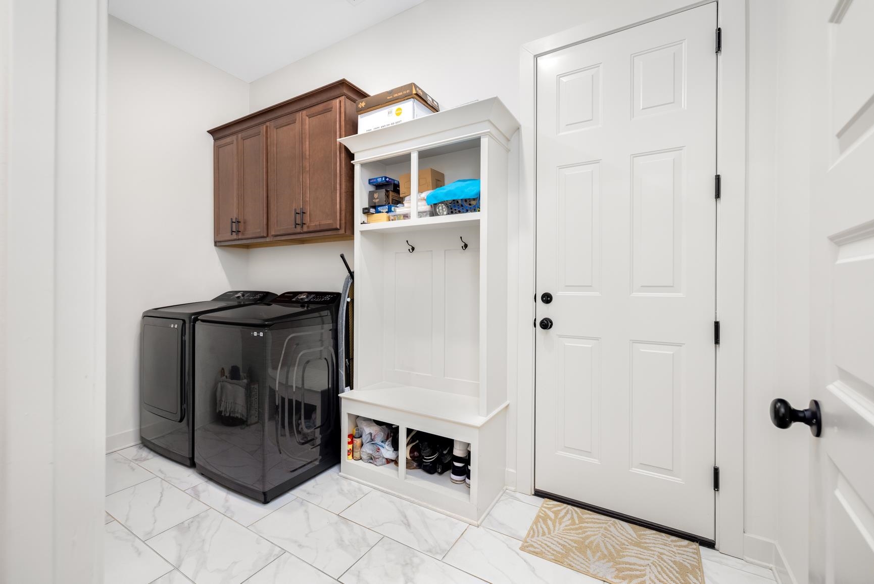 5628 Gerber Road Arlington, TN 38002 - Photo 36 of 40 Laundry room featuring light marble finish floors, independent washer and dryer, and cabinet space