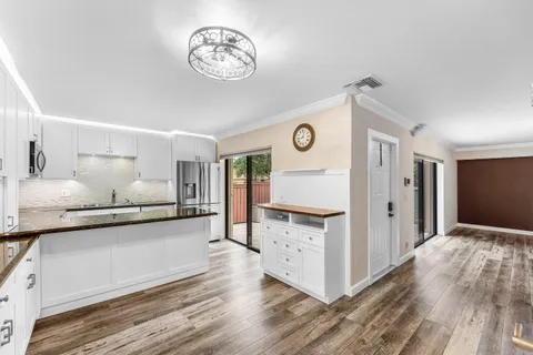a view of a kitchen with cabinets and wooden floor