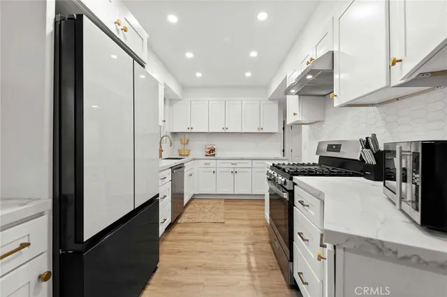 a kitchen with white cabinets and appliances