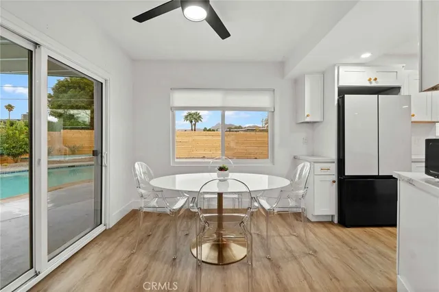 a dining room with furniture and a floor to ceiling window