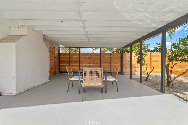 a view of living room with stainless steel appliances kitchen island granite countertop furniture and a window