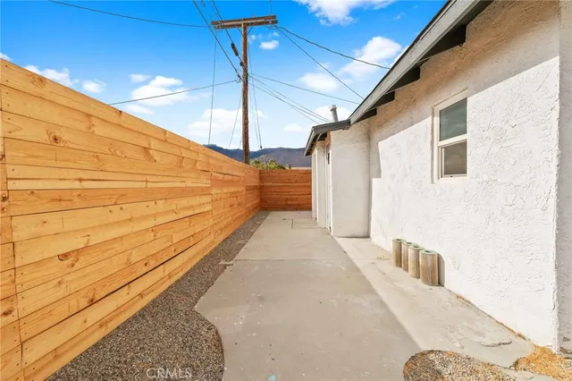 a porch with a table and chairs next to a yard