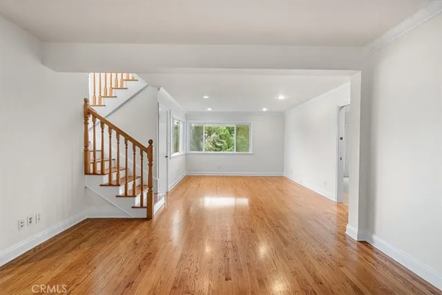a view of a hallway with wooden floor and staircase