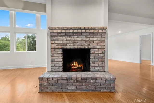 a view of a living room and kitchen with furniture wooden floor and fireplace