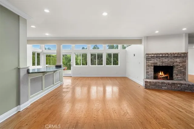 a view of empty room with wooden floor and fireplace
