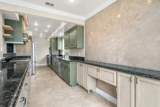 a kitchen with stainless steel appliances granite countertop a sink a stove and a wooden cabinets
