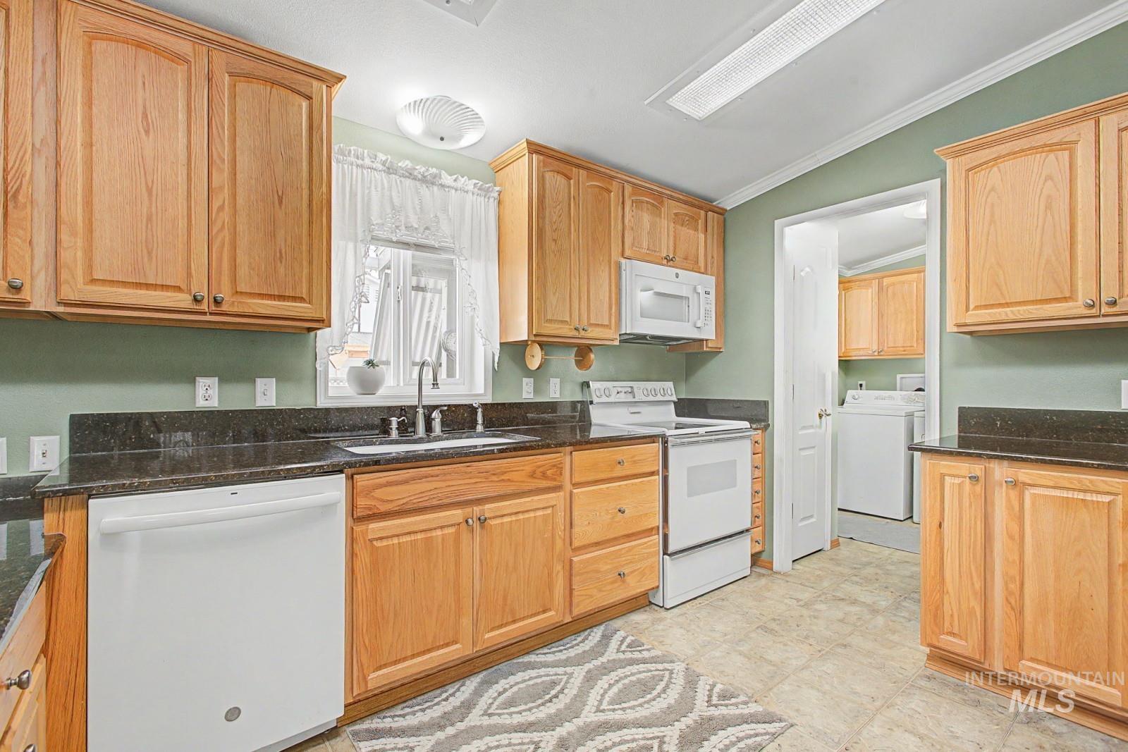 1480 Birch Street Clarkston, WA 99403 - Photo 12 of 30 Kitchen with white appliances, dark stone counters, washer / dryer, and ornamental molding